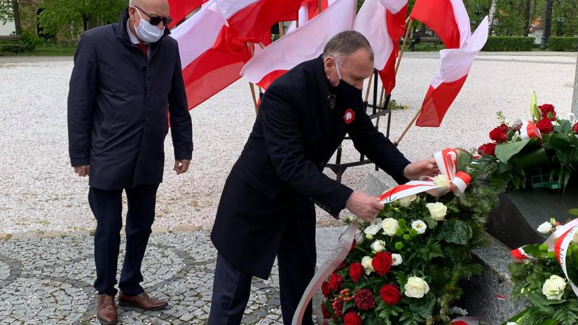 Prezydent Jerzy Łużniak składa kwiaty pod pomnikiem, w asyście przewodniczącego rady miejskiej Wojciecha Chadży.
