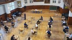 Uczniowie siedzą przy ławkach w auli I Liceum Ogólnokształcącego w Jeleniej Górze.