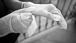 Dłonie zakładające rękawice tekstylne na ręce.