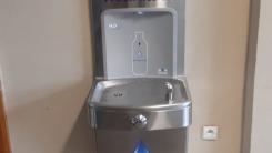 Urządzenie do podawania wody zainstalowane w korytarzu szkoły.
