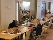 Szachistki po skończonej partii, siedzą przy szachownicy.
